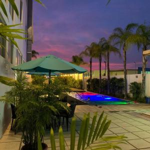 曼塔Aquamarina Hotel的庭院设有带遮阳伞的桌子和游泳池。