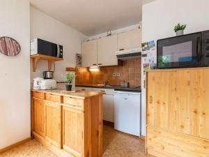 圣拉里苏朗Appartement Saint-Lary-Soulan, 1 pièce, 4 personnes - FR-1-296-350的一间带木制橱柜的厨房和一台墙上的电视