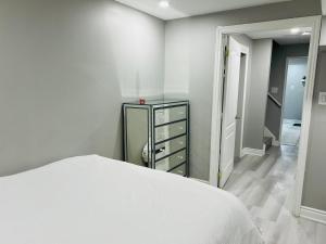 米尔顿Cozy 1 BR basement apartment with Free Street Parking & Separate Entrance的卧室配有白色的床和梳妆台。
