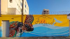 瓜拉派瑞Casa Amarela Hostel的黄墙上的乌龟壁画