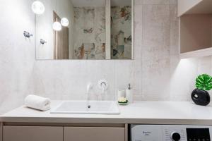 海若克利欧Euphoria Luxury Apartment的白色的浴室设有水槽和镜子