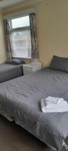 北帕默斯顿Pennys Accommodation的卧室内的一张床位,卧室设有窗户和床罩