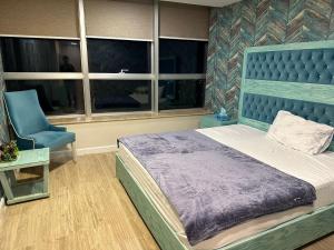 伊斯兰堡Centaurus Apartment Islamabad的一间卧室配有蓝色的床和蓝色椅子