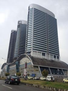 伊斯兰堡Centaurus Apartment Islamabad的一座大型建筑,前面有汽车停放