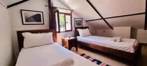 培拉特Hotel Gorica - UNESCO quarter的一间卧室设有两张床和窗户。