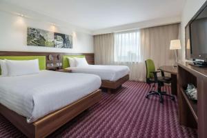 伯明翰希尔顿伯明翰大街汉普顿酒店的酒店客房设有两张床、一张桌子和一台电视。