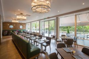 布里斯托希尔顿花园布里斯托尔市中心旅馆的餐厅设有桌椅和窗户。