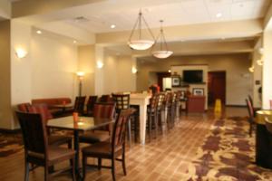威廉斯堡威廉斯堡汉普顿酒店的一间带桌椅的餐厅和一间酒吧