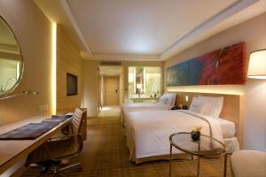 吉隆坡吉隆坡希尔顿逸林酒店的酒店客房配有两张床和一张书桌