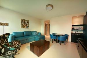 巴拿马城巴拿马城汉普顿希尔顿酒店的客厅配有蓝色的沙发和桌子