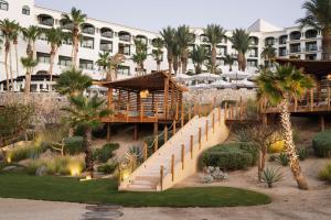 圣何塞德尔卡沃Hilton Los Cabos的一座拥有楼梯和棕榈树的度假村和一座建筑