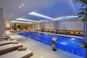 伊斯坦布尔伊斯坦布尔图兹拉希尔顿逸林酒店的酒店游泳池设有躺椅和酒吧