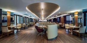 伊斯坦布尔伊斯坦布尔托普卡匹希尔顿逸林酒店的一间带桌椅的餐厅和一间酒吧