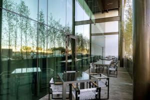 阿瓜斯卡连特斯Hilton Garden Inn Aguascalientes的配有桌椅和大型玻璃窗的餐厅