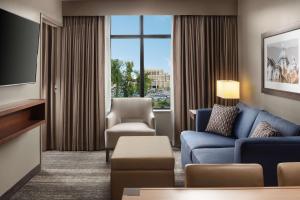 南本德Embassy Suites by Hilton South Bend的客厅配有沙发、椅子和电视
