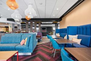 波特兰Tru By Hilton Portland Airport, Or的一间配备有蓝色家具和桌子的等候室