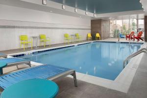 哥伦布Home2 Suites By Hilton Columbus Polaris的游泳池配有五颜六色的桌椅