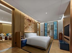 儋州海南海花岛希尔顿酒店的一间带白色床的卧室和一间客厅