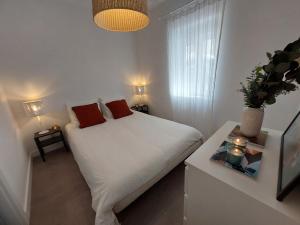 里斯本Cosy, Stylish, Central的卧室配有白色床和2个红色枕头