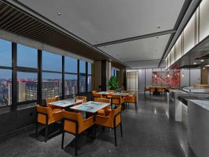 成都成都滨江希尔顿逸林酒店的餐厅设有桌椅和窗户。