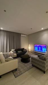 利雅德شقة انيقة باثاث فاخر的客厅配有2张沙发和1台平面电视