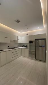 利雅德Luxury Apartment的厨房配有白色橱柜和不锈钢用具