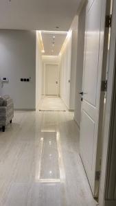 利雅德Luxury Apartment的白色走廊,有门和房间