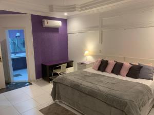 瓜鲁雅Hotel The Green Ecologic的一间卧室设有一张大床和紫色的墙壁