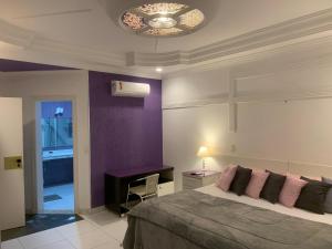 瓜鲁雅Hotel The Green Ecologic的一间卧室配有一张床和紫色的墙壁