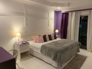 瓜鲁雅Hotel The Green Ecologic的一间卧室配有一张大床和紫色墙壁