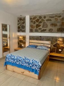索里托斯La Tablita的一间卧室设有一张床和石墙