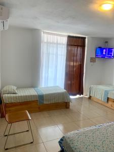 索里托斯La Tablita的一间卧室设有两张床,墙上配有电视。