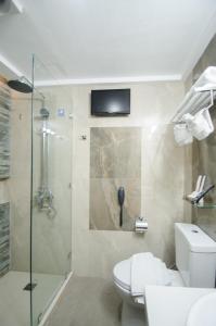 长滩岛长滩岛红可可旅馆的一间带卫生间和淋浴及电视的浴室