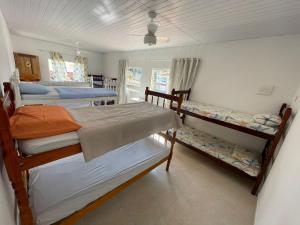 瓜拉派瑞Casa Amarela Hostel的一间卧室配有三张双层床。