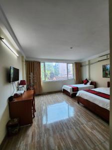 河内Phương Thảo Hotel的酒店客房设有两张床和电视。