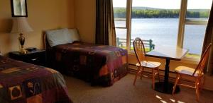 巴德克St Ann's Motel & Cottage的酒店客房带一张床、一张桌子和椅子