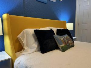坦帕Luxury Suite by Tampa Convention Center & Hospital的一张配有黑白枕头的床和黄色床头板