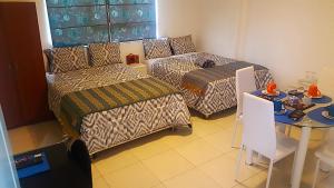 特鲁希略Magicperu Apart Hotel的客厅配有沙发和桌子