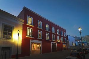 瓜纳华托Hotel Indigo Guanajuato, an IHG Hotel的街上的红色建筑,有两盏路灯