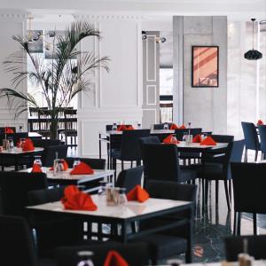 安吉利斯Hevea Hotel & Resort的用餐室配有桌椅和红色餐巾