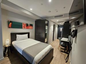 悉尼8号一室公寓酒店 - 仅限成人的一间卧室配有一张床、一张桌子和一台电脑