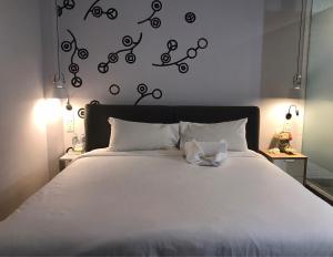 曼谷贝德普勒蒂旅舍的一间卧室配有一张带白色床单和黑色调的床。
