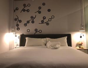 曼谷贝德普勒蒂旅舍的一间卧室配有白色床单和灯。