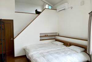 富良野ADVENTURe (アドベンチャー)的卧室配有白色的床和2个枕头