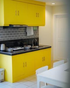 KababaeEmerald Manor Hotel的厨房配有黄色橱柜和水槽