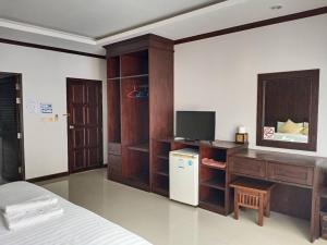蔻立Chongfah Mountain View的一间卧室配有一张床和一张书桌及电视