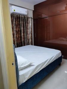 维沙卡帕特南Rahuls castle的一间卧室配有一张带白色床单的床和窗户。