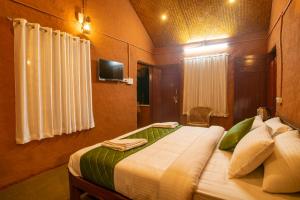 KanthalloorFOOD FOREST KANTHALLOOR的一间卧室设有一张大床,配有电视