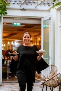 布雷达Ruim comfortabel appartement centrum Breda MET restaurant!的女人拿着一盘食物