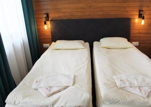 波罗维茨波罗维茨花园公寓PM服务酒店的两张睡床彼此相邻,位于一个房间里